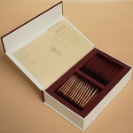 Close-up of gold and red sachets neatly arranged in tea box
