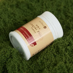 White_plastic_bottle_of_Oriherb_Lingzhi_Plus_tablets_lying_on_green_moss_background